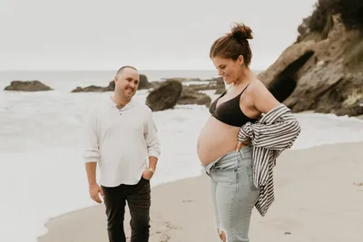 Couple sharing a moment as she lifts her shirt to reveal a pregnant belly