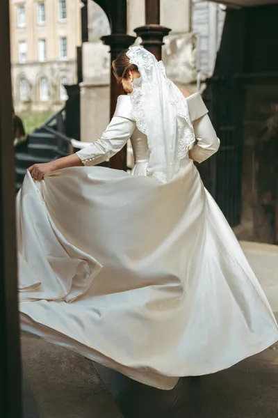 Bride swirling her dress in a stone doorway
