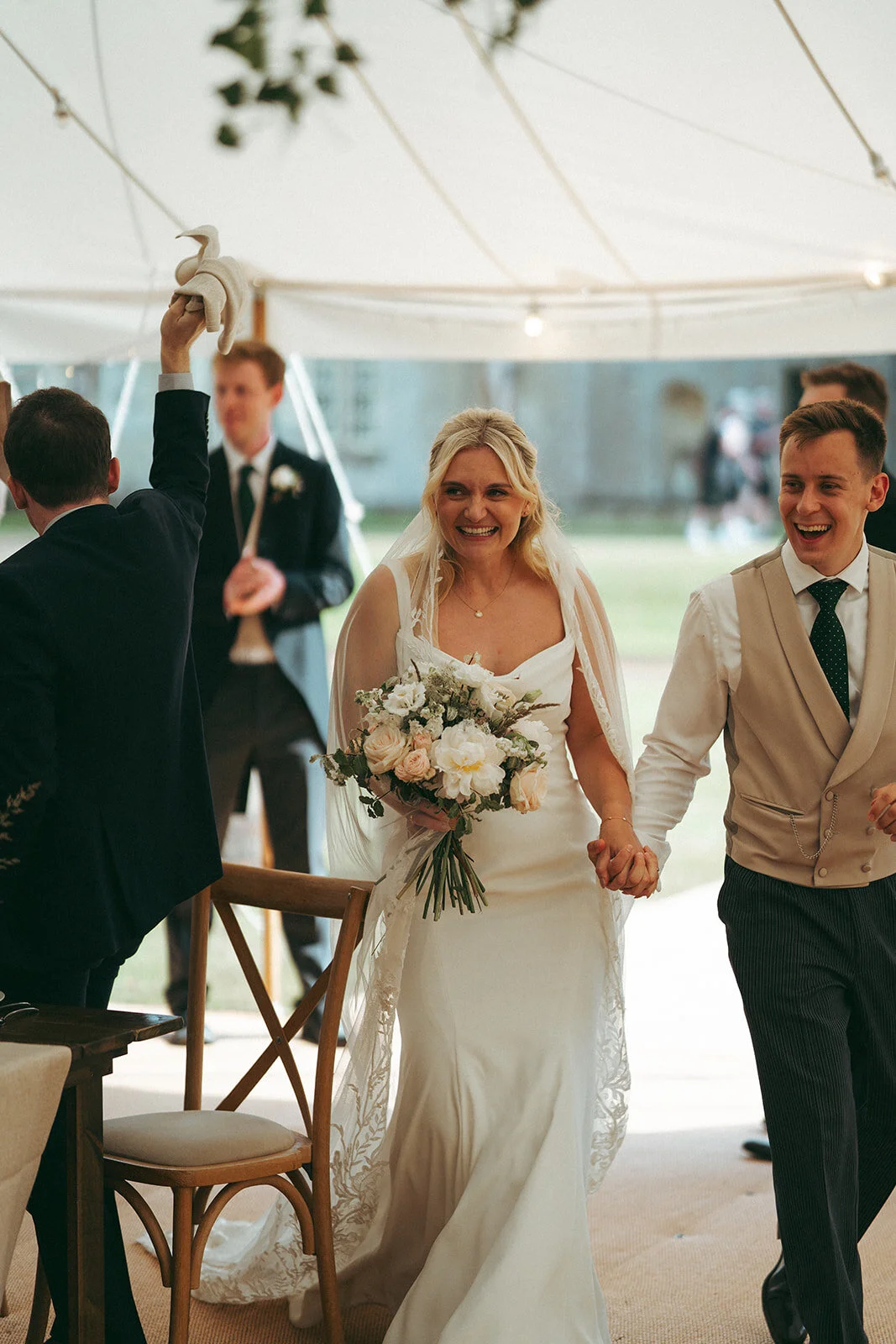 The couple arriving in the marquee, hand in hand